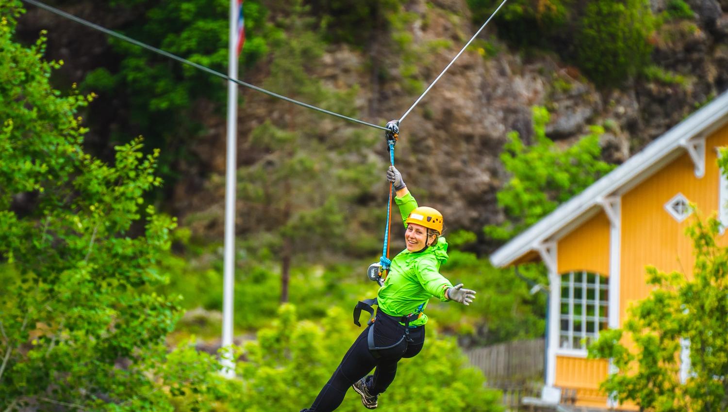Kvinne på vei ned i zip-linen i Via ferrata Haldenkanalen