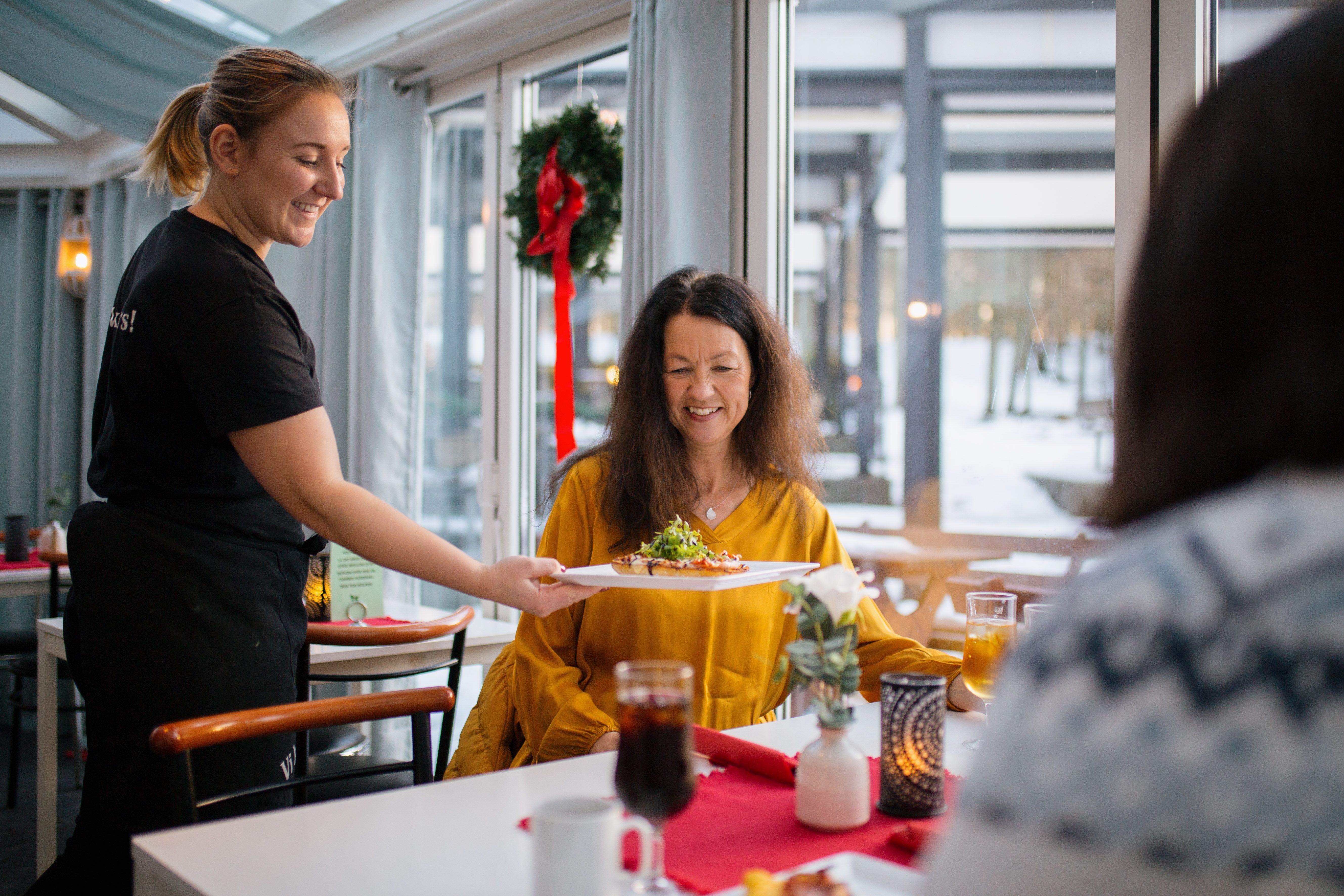 Servitør serverer mat på bordet