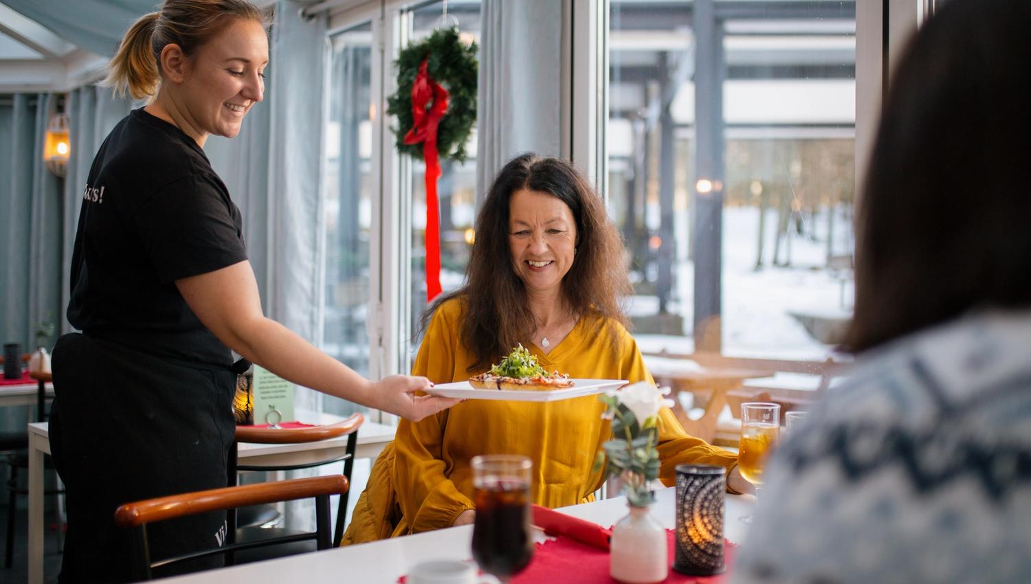 Servitør serverer mat på bordet