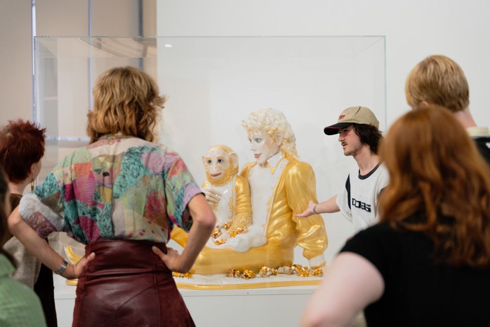 People looking at the sculpture "Michael Jackson and Bubbles"