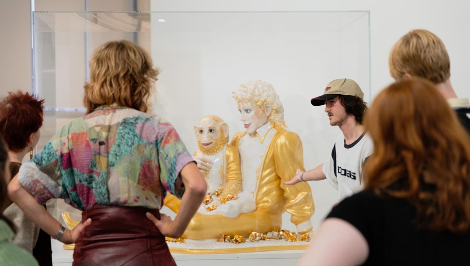 People looking at the sculpture "Michael Jackson and Bubbles"