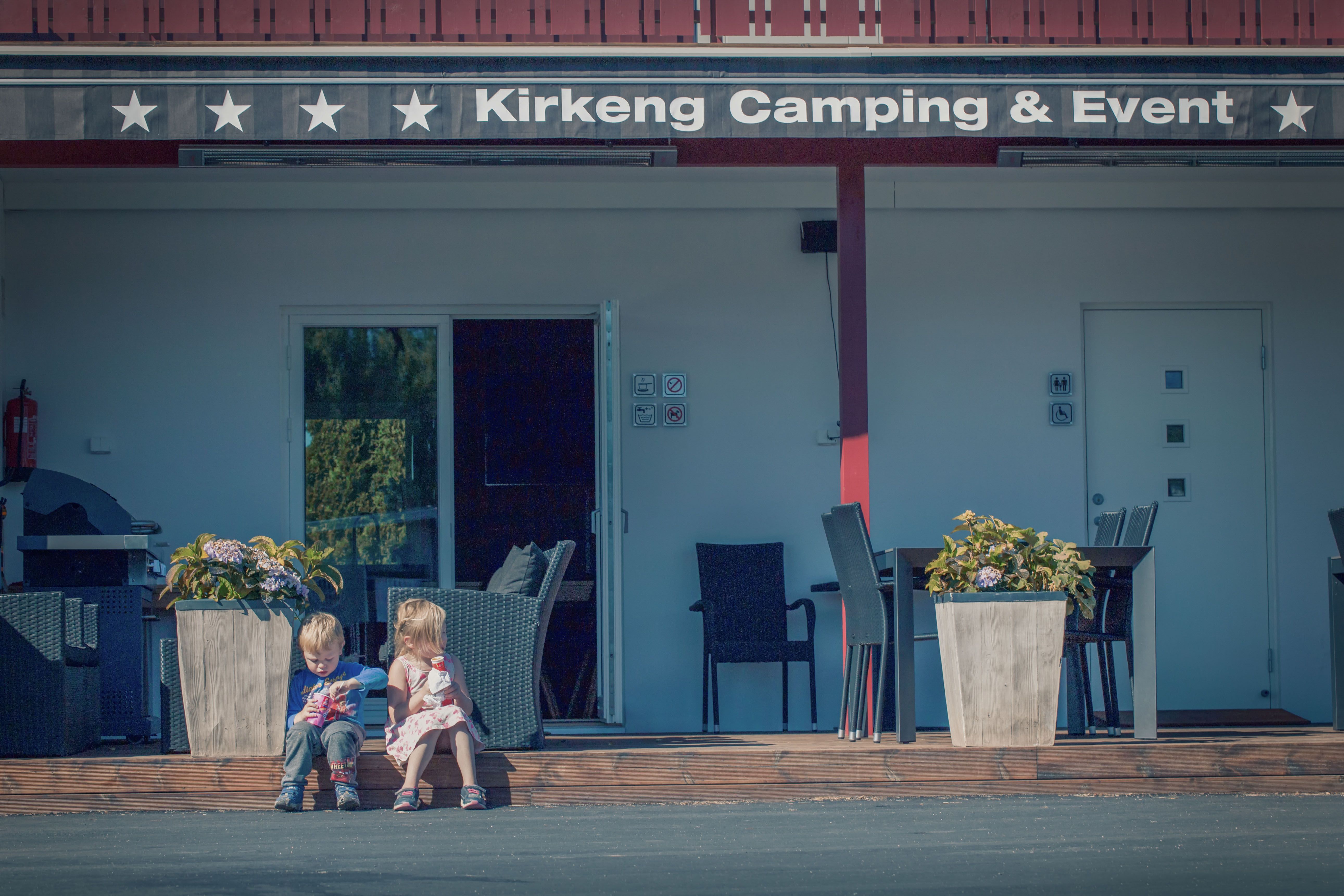 Two children sit along the edge and eating ice cream