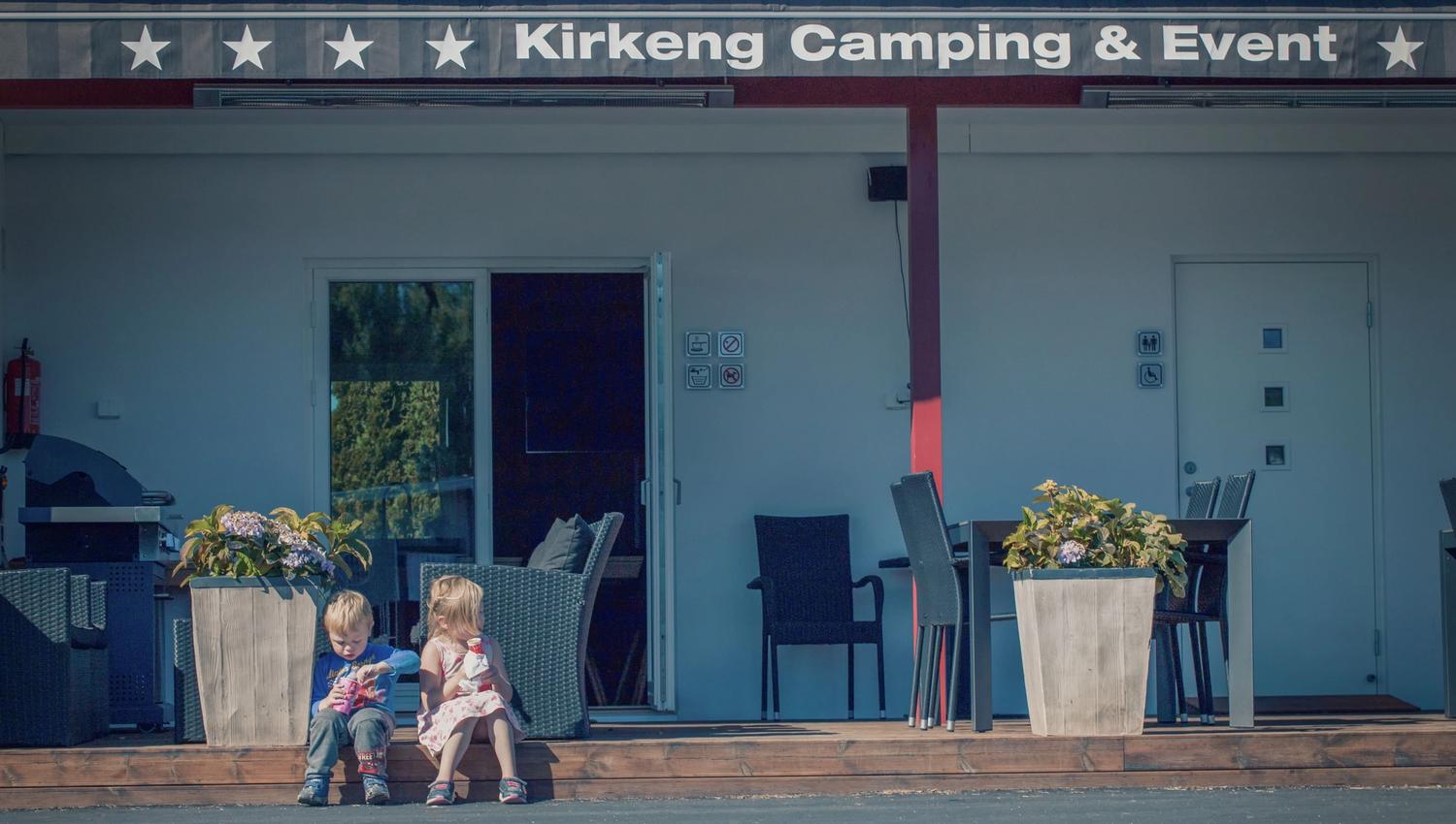 Two children sit along the edge and eating ice cream