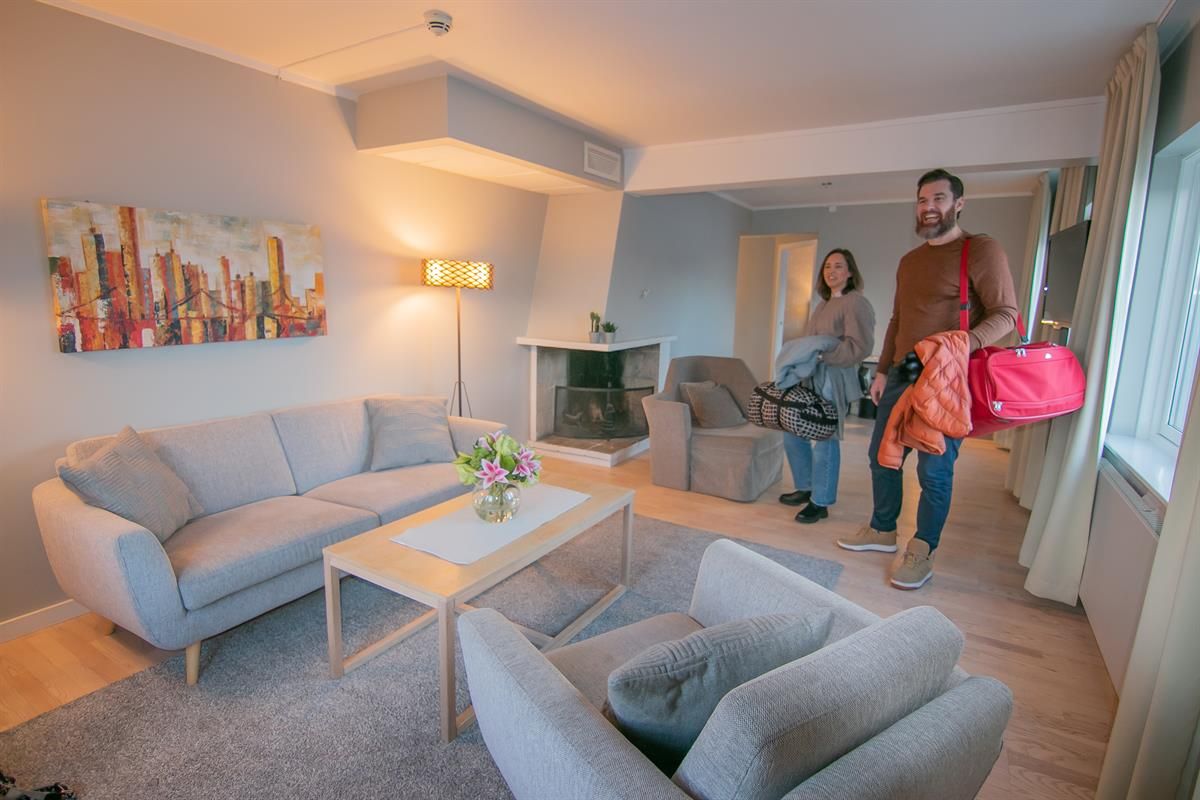 Hotell i Hamar. Familie i moderne hotellrom med sittegruppe.