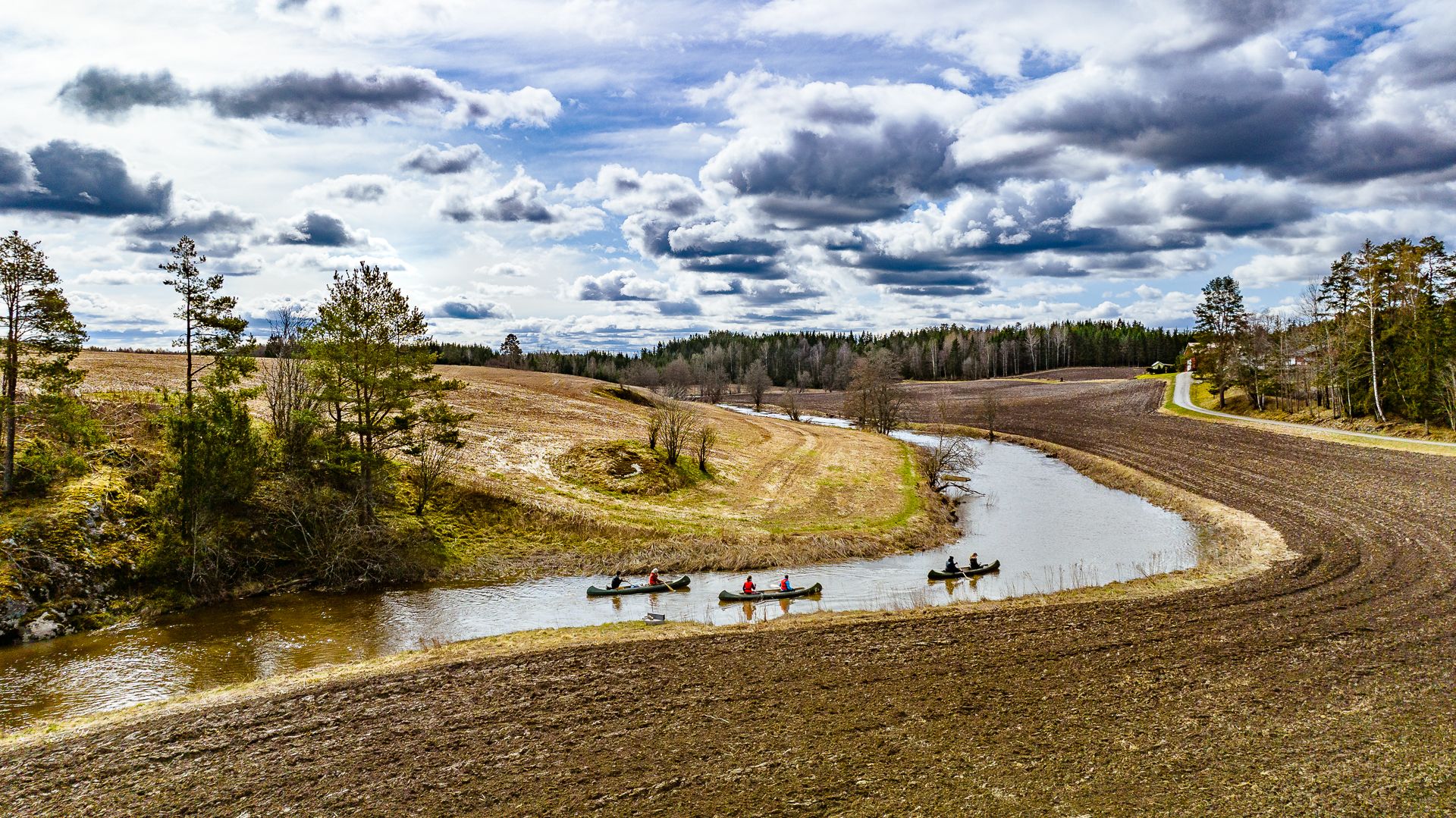 padler kano mellom jorder