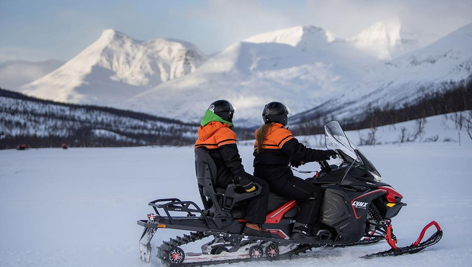 Guests look out over the mesmerising mountains from their snow scooter