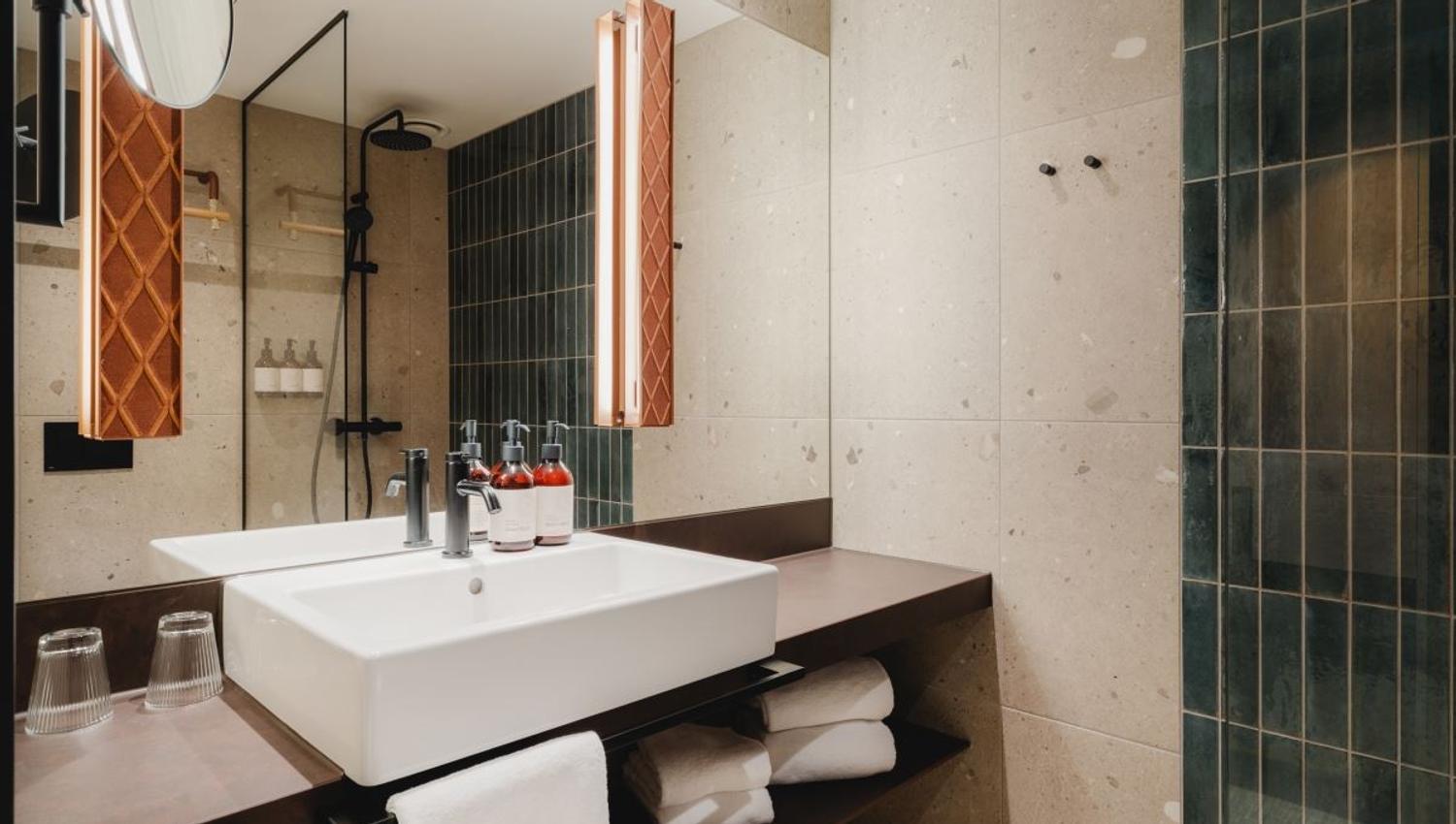 Modern bathroom with sink, mirror, and glass-walled shower