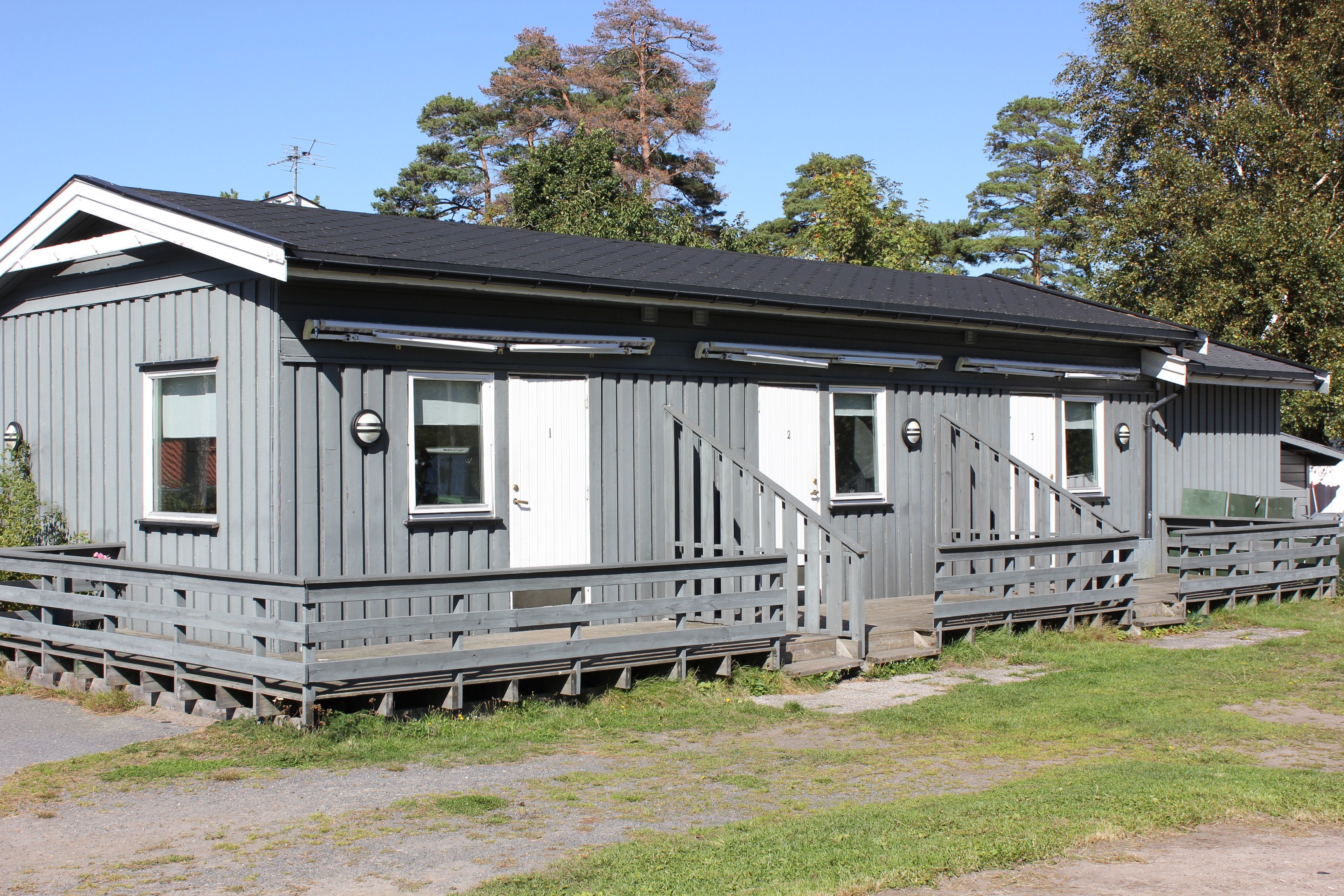 Gray building with three apartments on one level