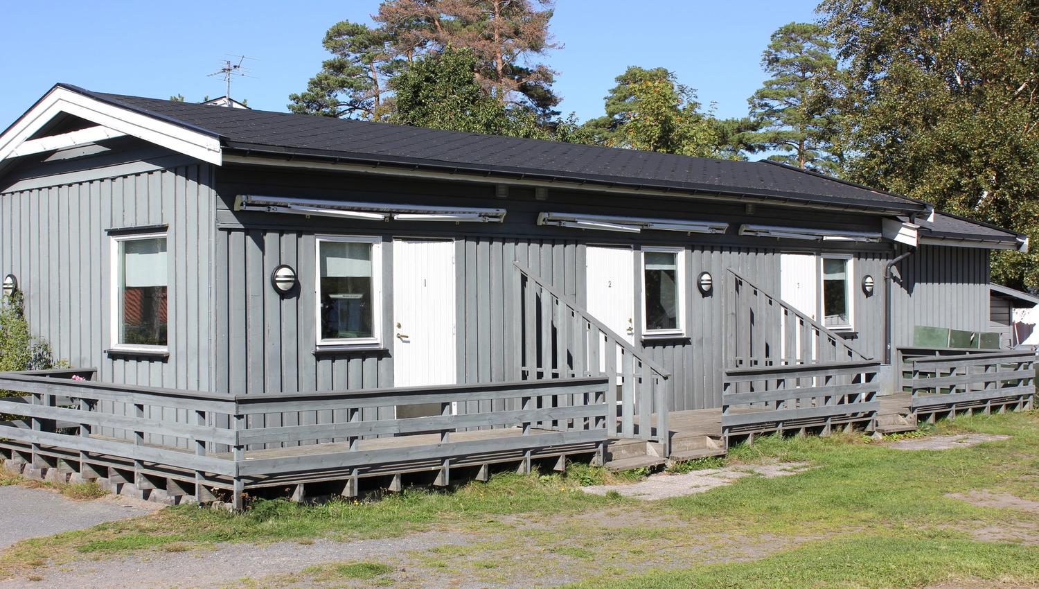 Gray building with three apartments on one level