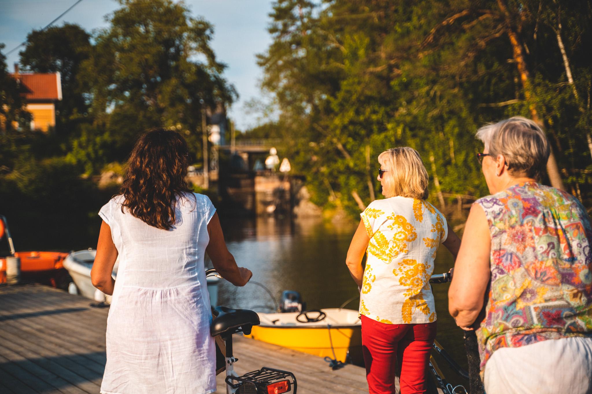 tre damer går på bryggen