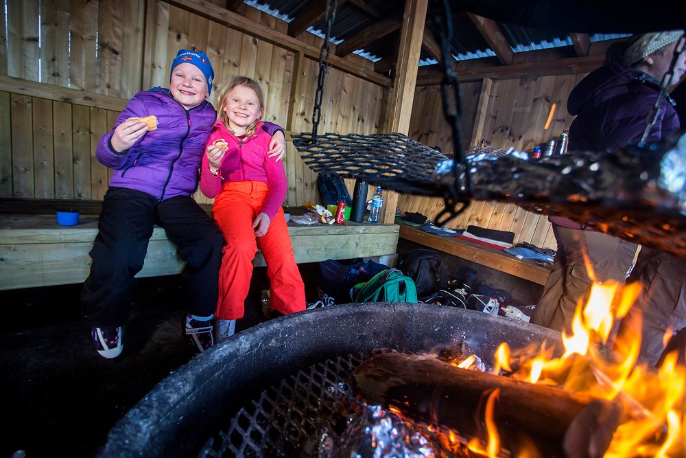 barn koser seg med pølse på bålplassen ved skøytebanen i Skien fritidspark