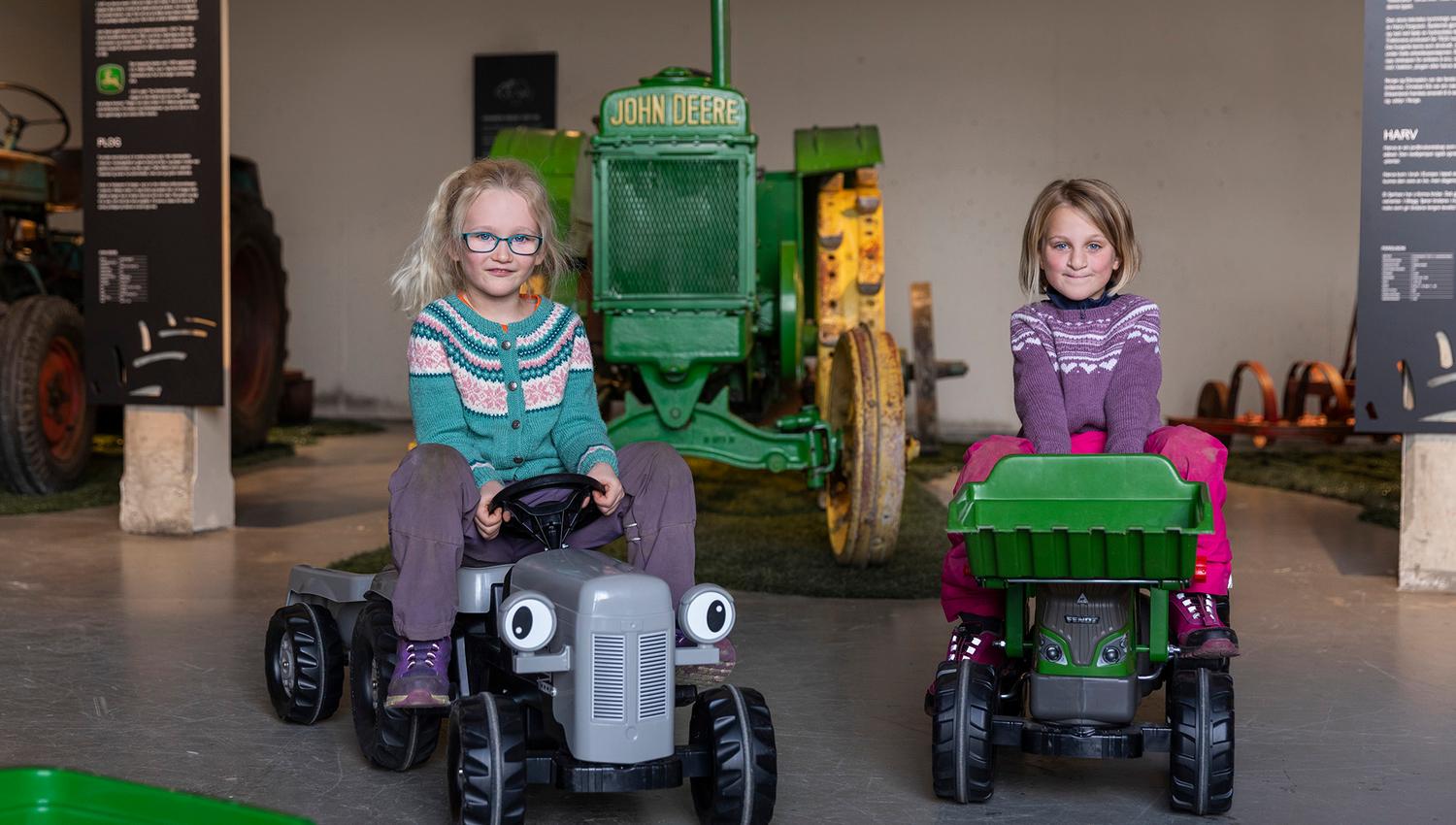 Jentene leker med traktorene i lekeområdet på Egge Museum
