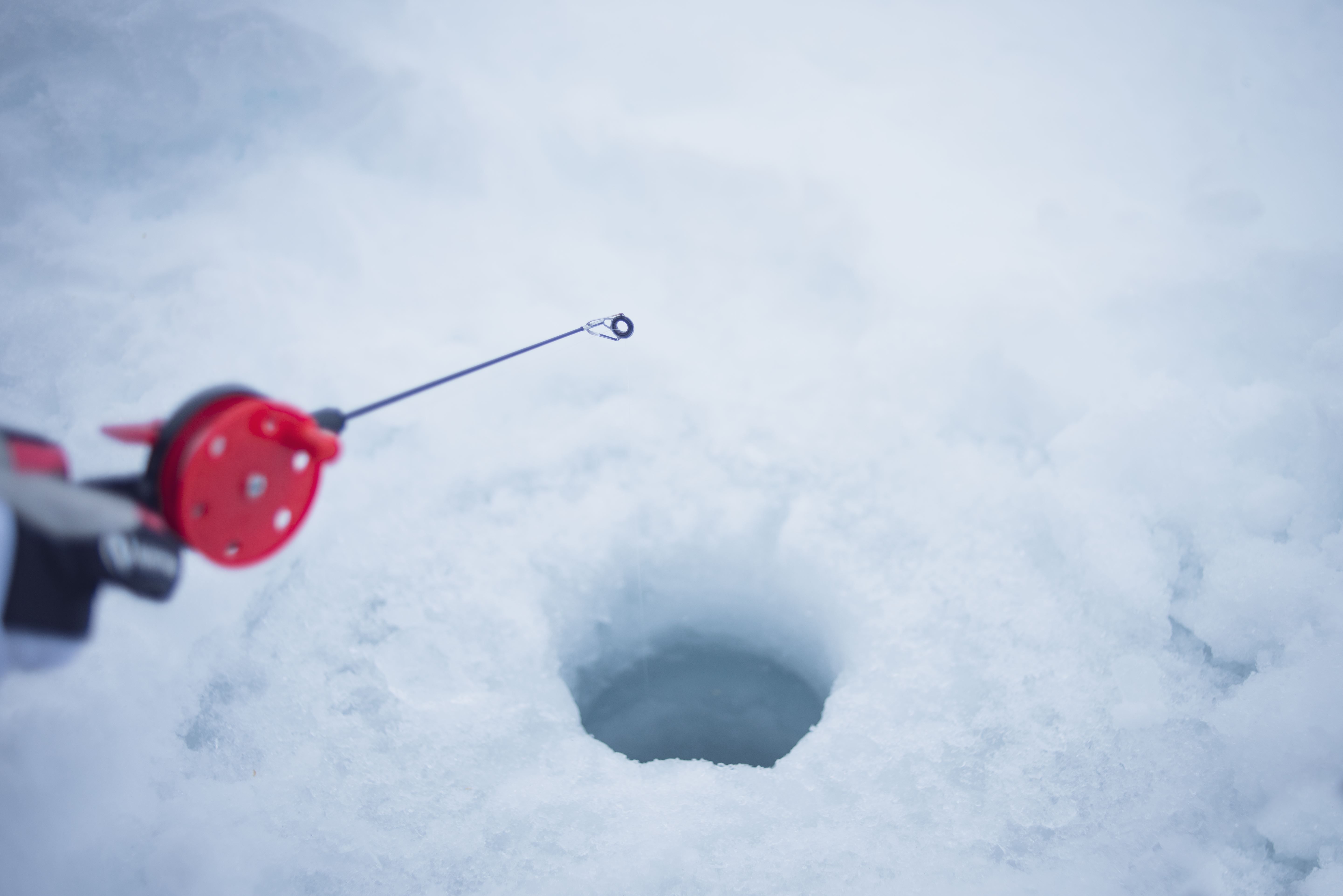 ice fishing in a hole in the ice