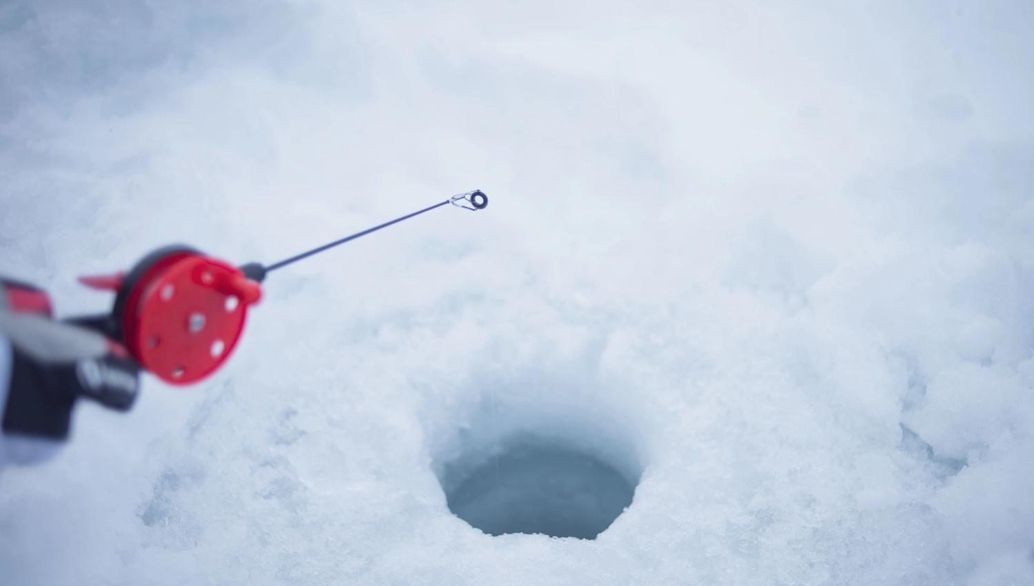 ice fishing in a hole in the ice