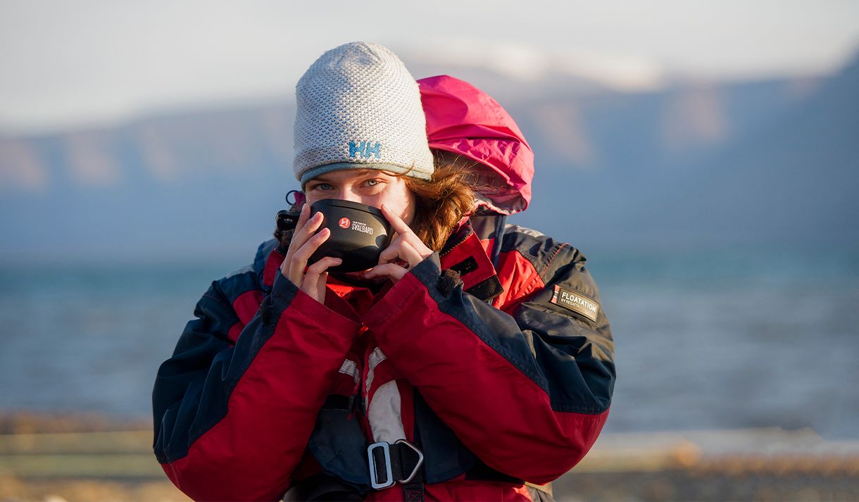A guest looking into the camera while drinking from a plastic cup