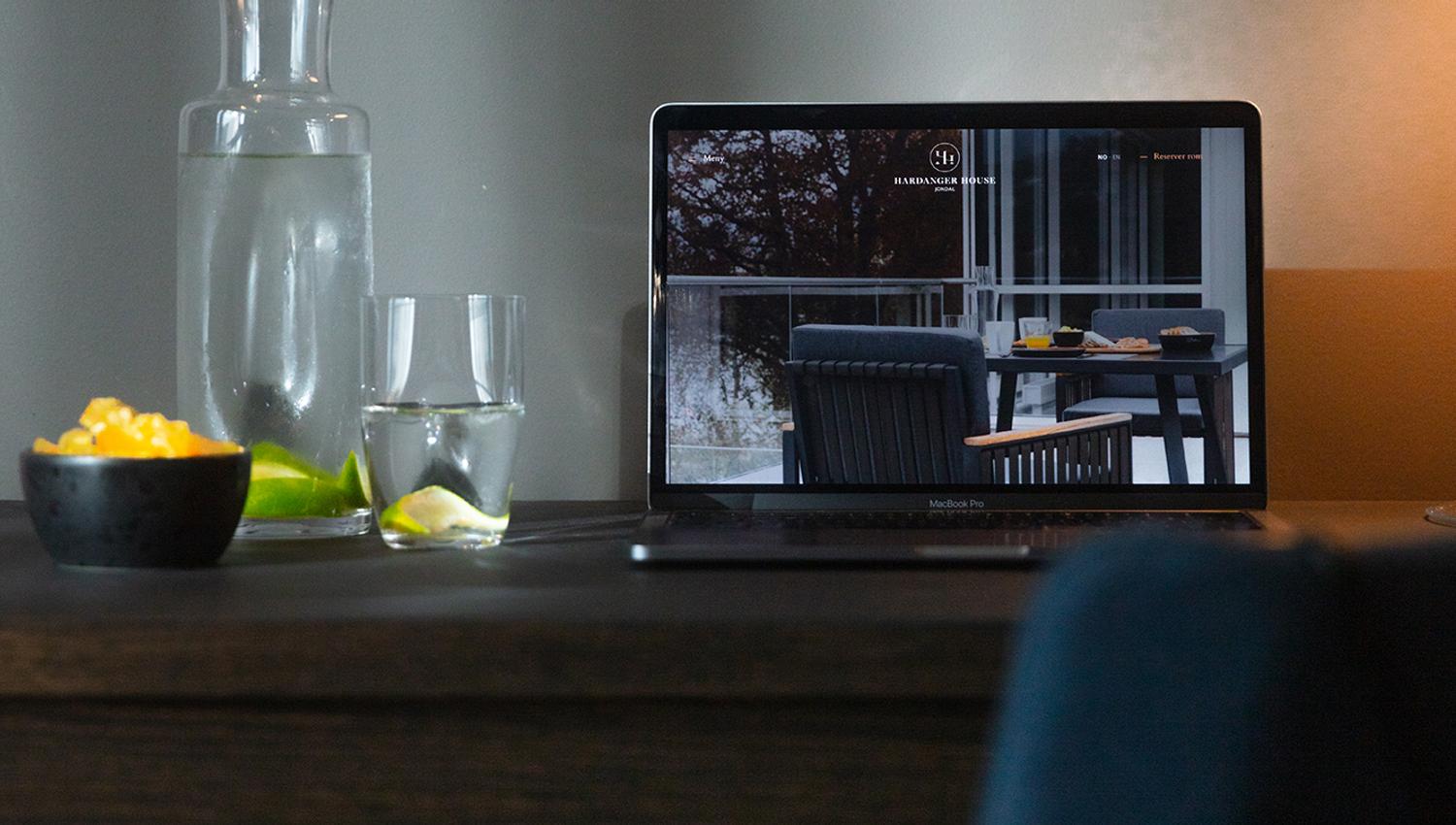 Workspace with laptop and refreshments at Hardanger House, ideal for productivity.