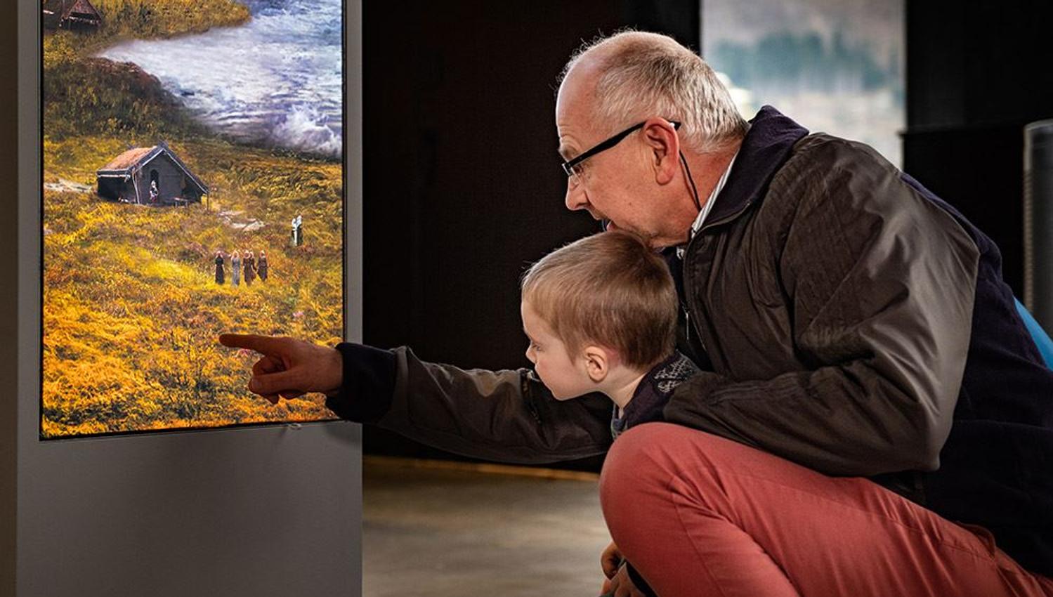 Barn og bestefar utforskar utstillingane saman på Sagastad Vikingsenter.