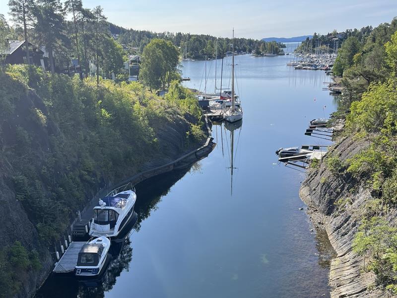 Smalt sund med båter i havn