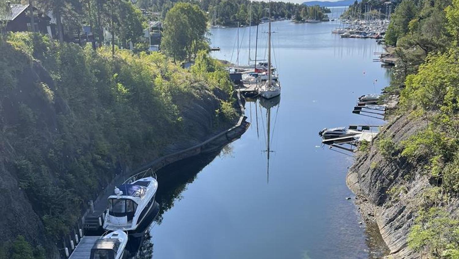 Smalt sund med båter i havn
