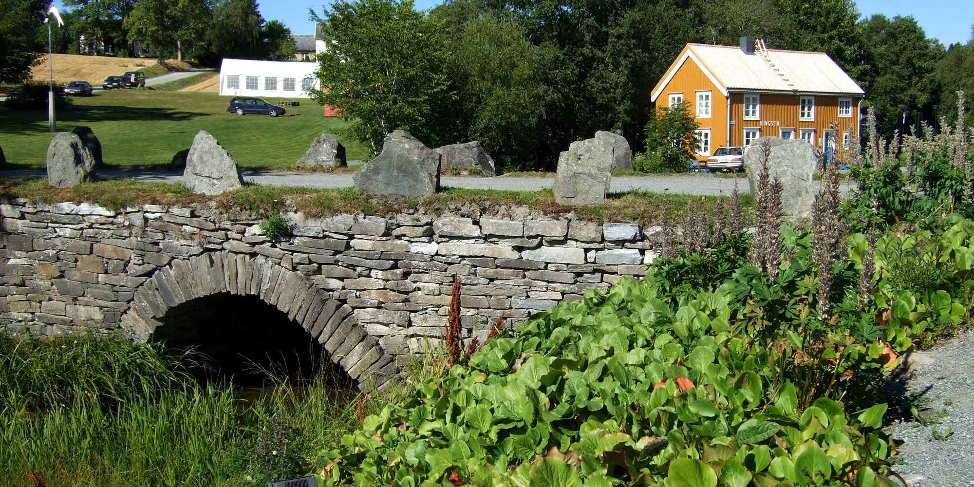 bilde av Muustrøbrua med Ringstu i bakgrunnen.