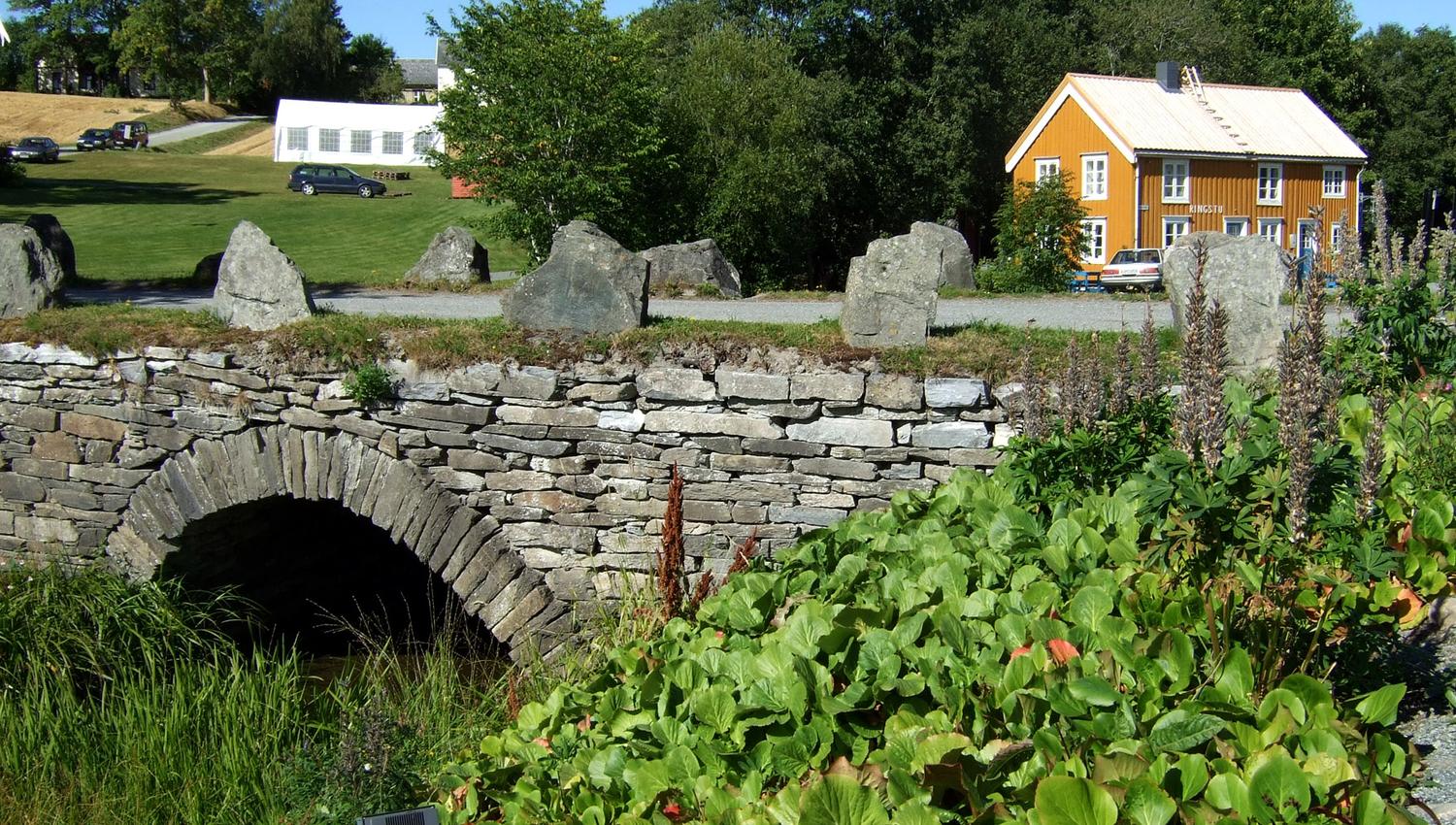 bilde av Muustrøbrua med Ringstu i bakgrunnen.