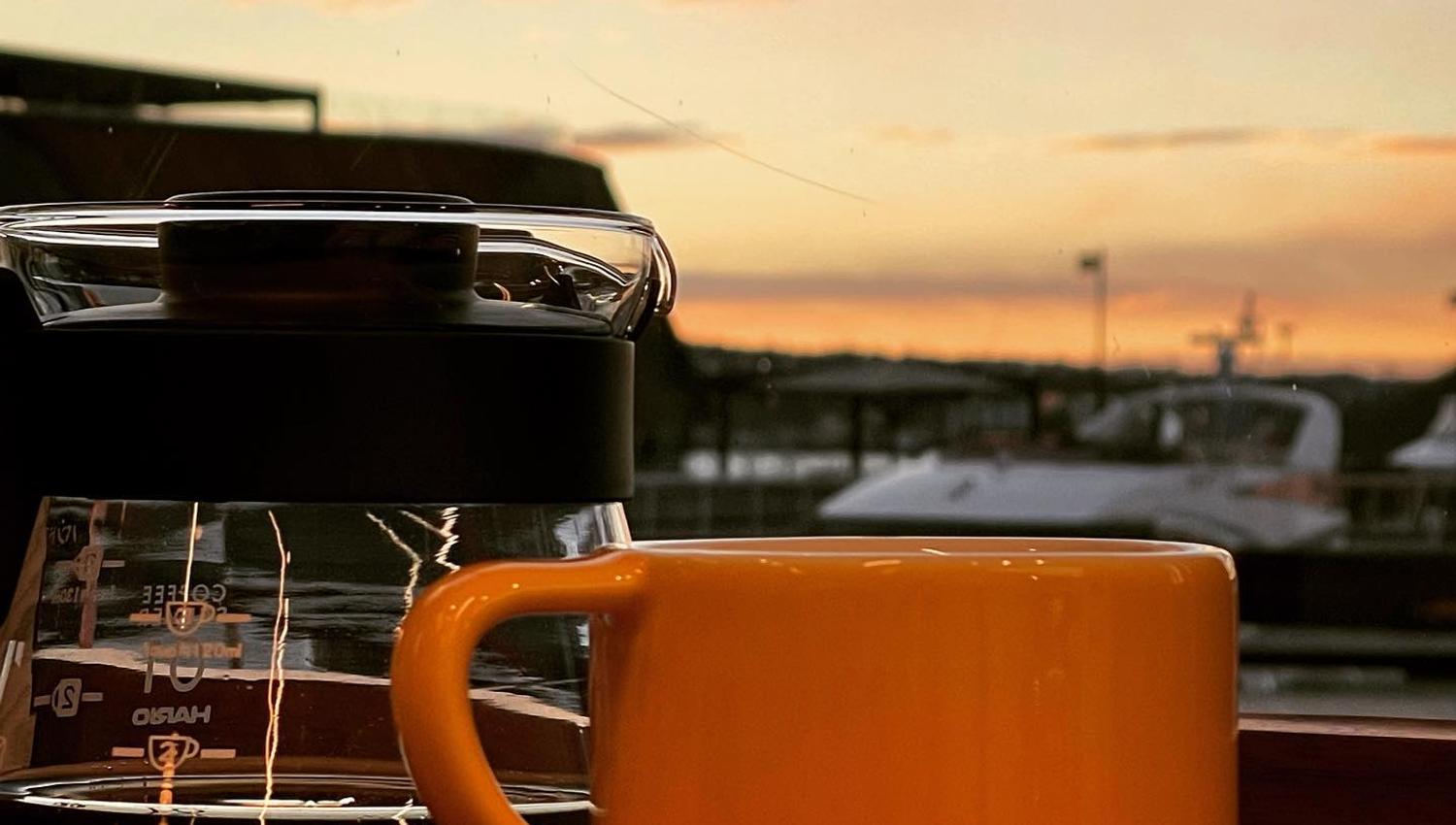 en kopp fra supreme roastwork og en kaffekanne med utsikt mot aker brygge