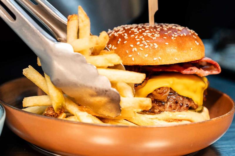 Detalj av cheeseburger og pommes frites