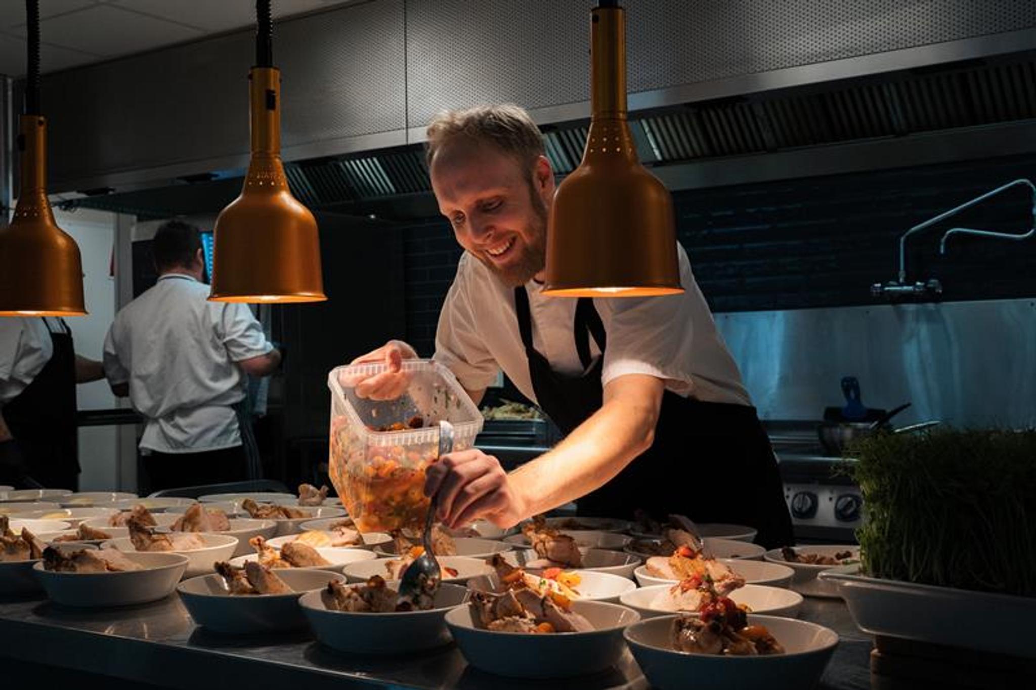 Chef puts food on plates 