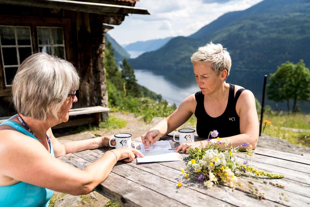 2 damer som sitter ved et bord ved Rui-plassen og ser på kart