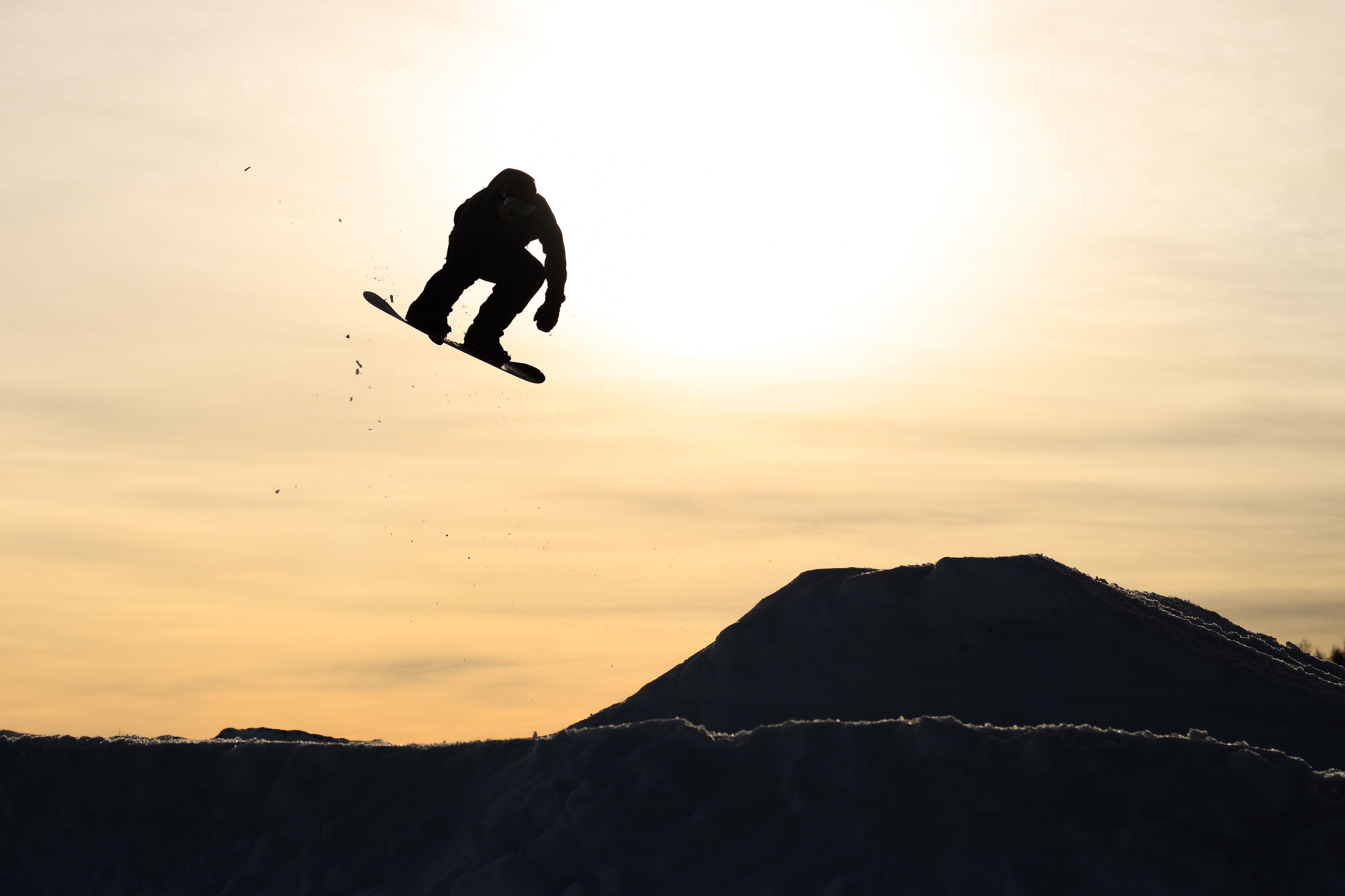 Gutt på snøbrett i solnedgangen, bilde