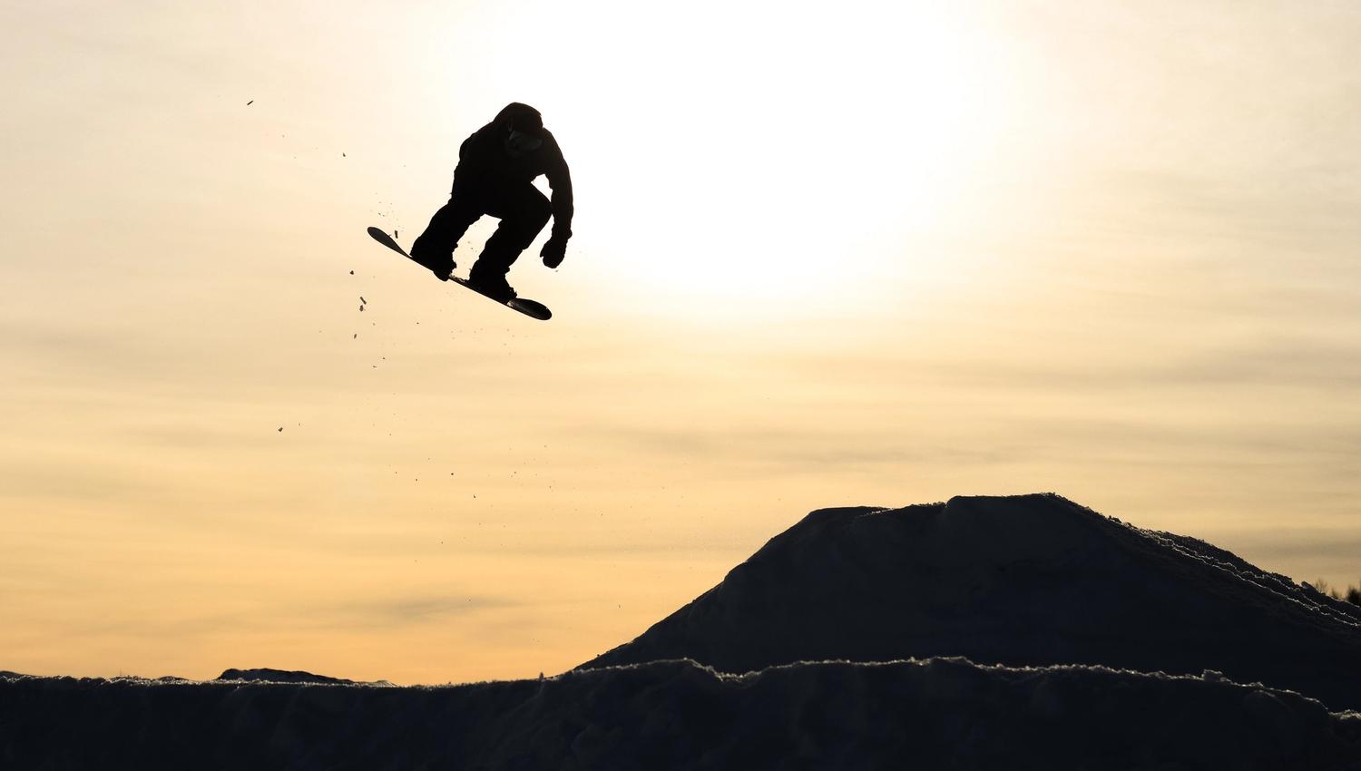 Gutt på snøbrett i solnedgangen, bilde