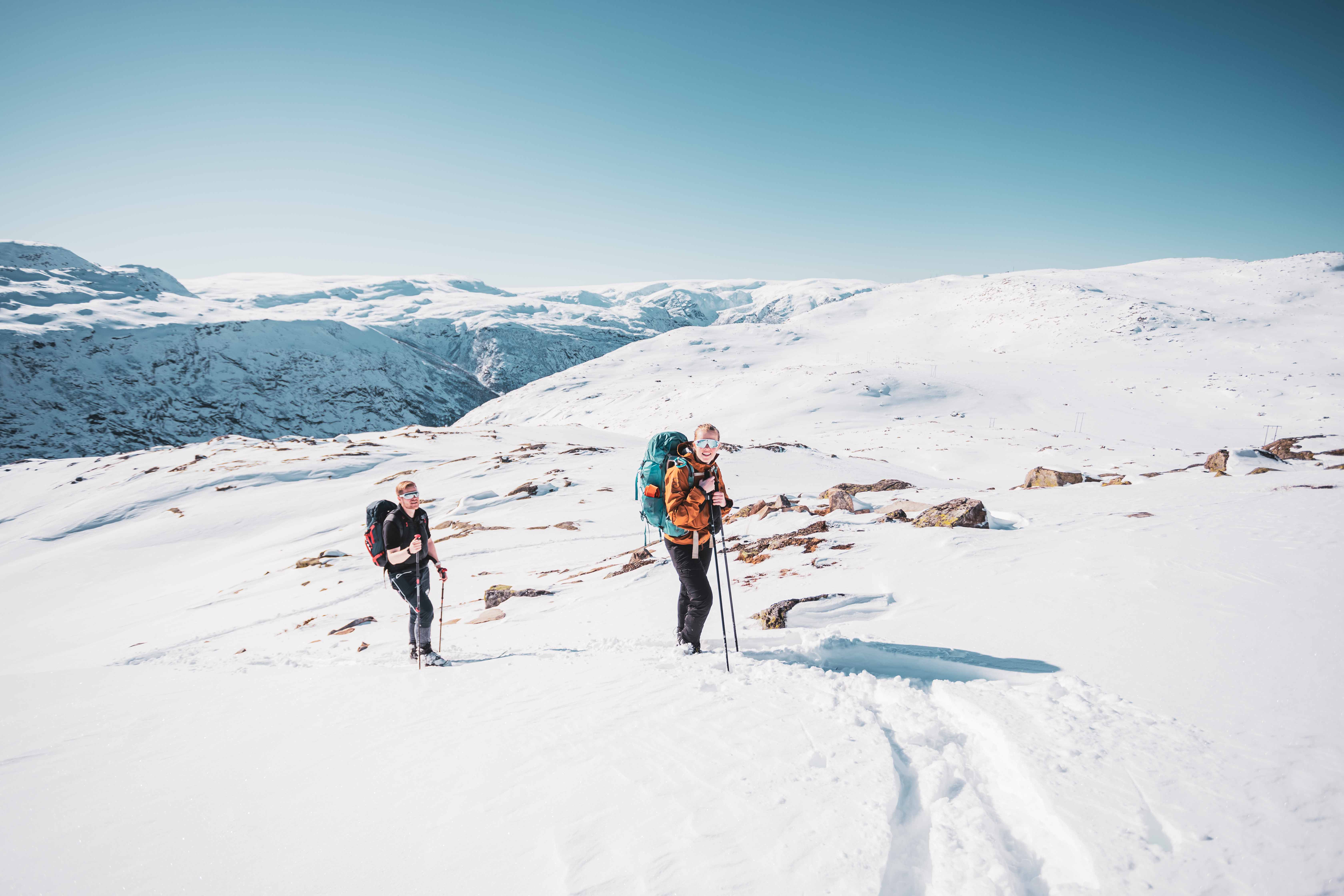 To deltakarar på vintertur med ryggsekkar og snøsko nær Trolltunga.