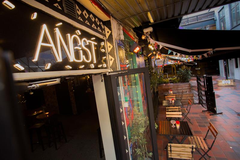 Exterior of bar sign, as well as the outdoor seating.