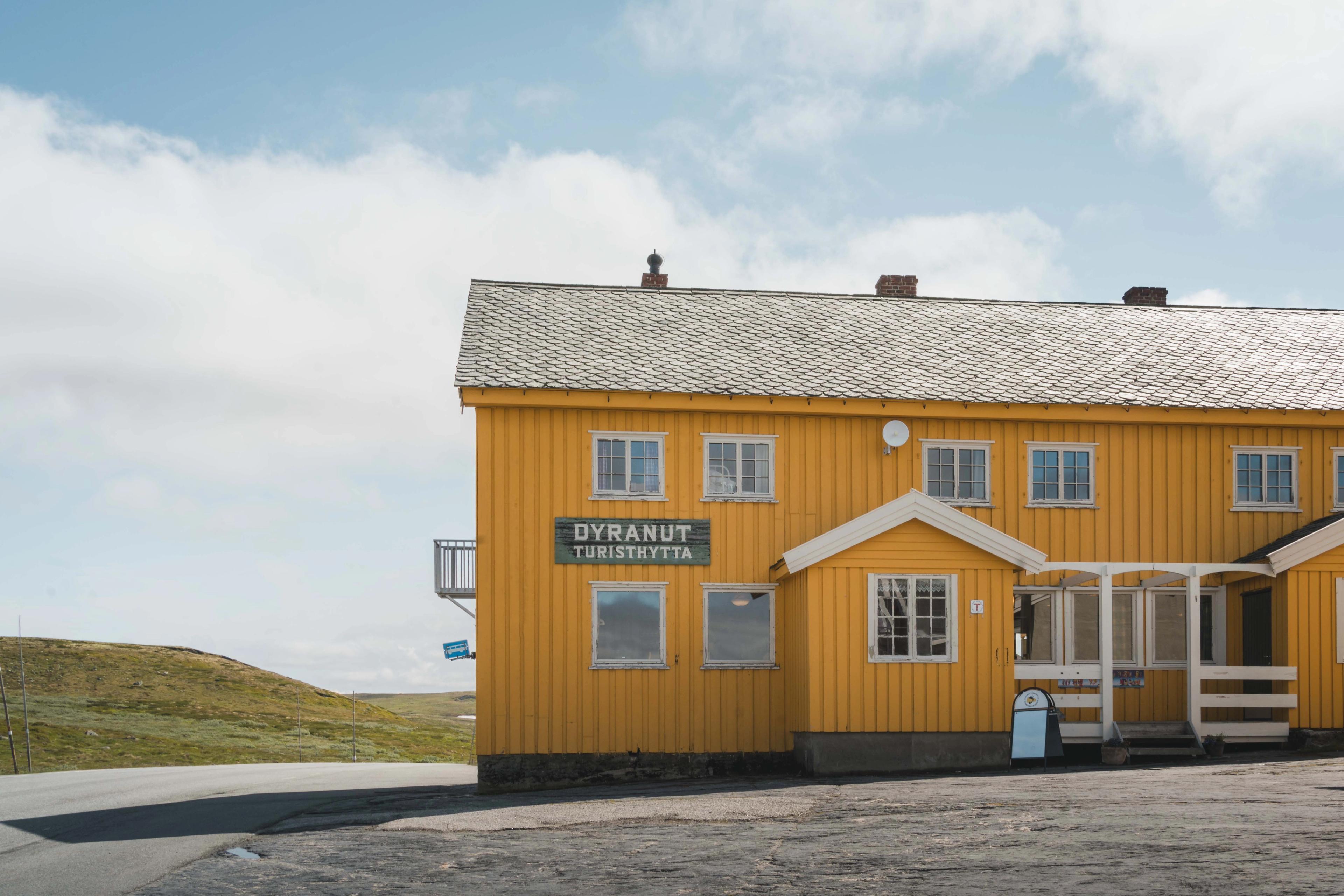 Den gule Dyranut Turisthytta, med blå himmel i bakgrunnen.