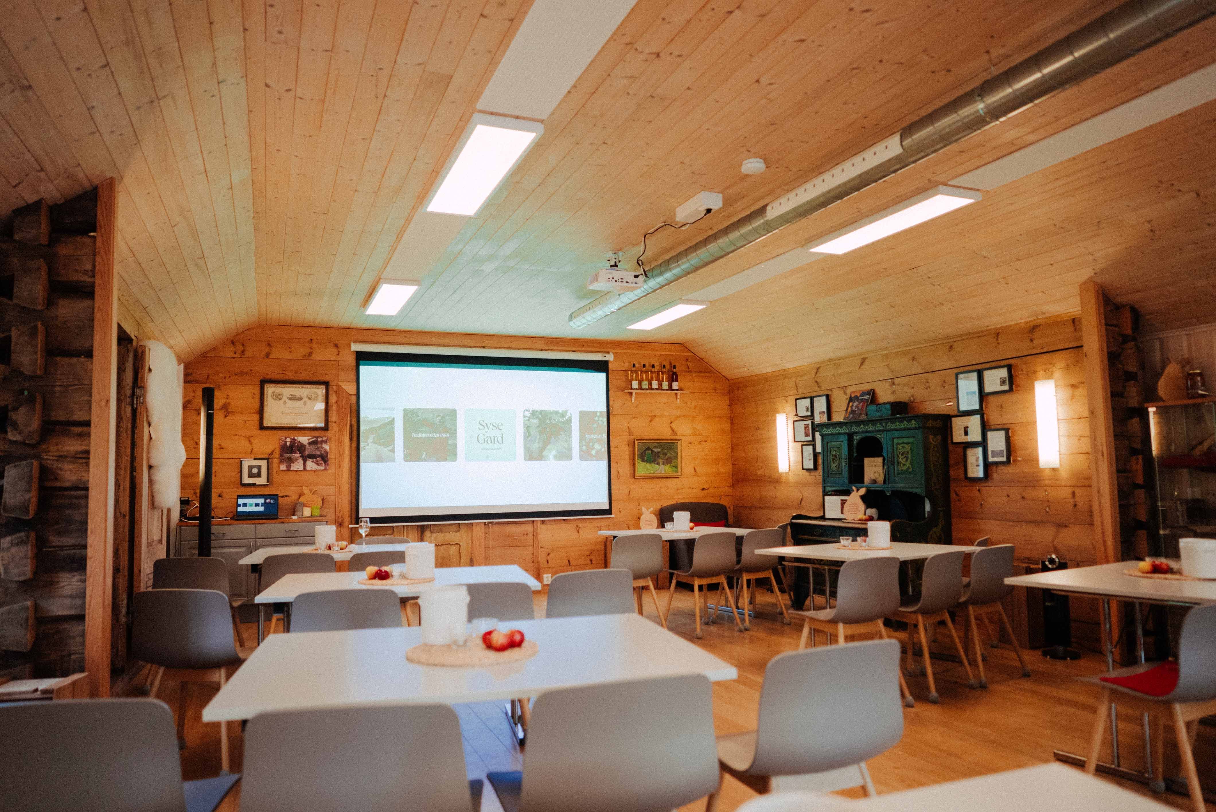 Konferanserom på Syse Gard med plass til arrangement og presentasjonar.