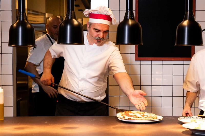 Kokk Francesco De Palma som tar en pizza ut av ovnen