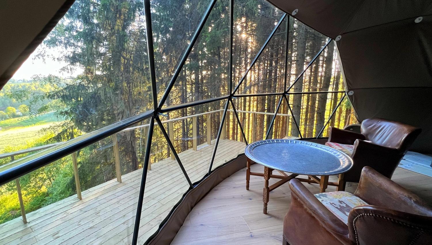 WonderInn Dome with chairs and table overlooking the forest and forest