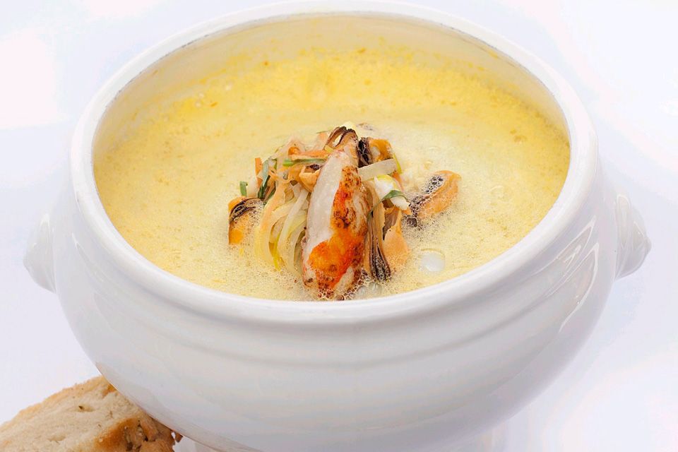 Detaljbilde av en suppe i en skål med brød ved siden av.