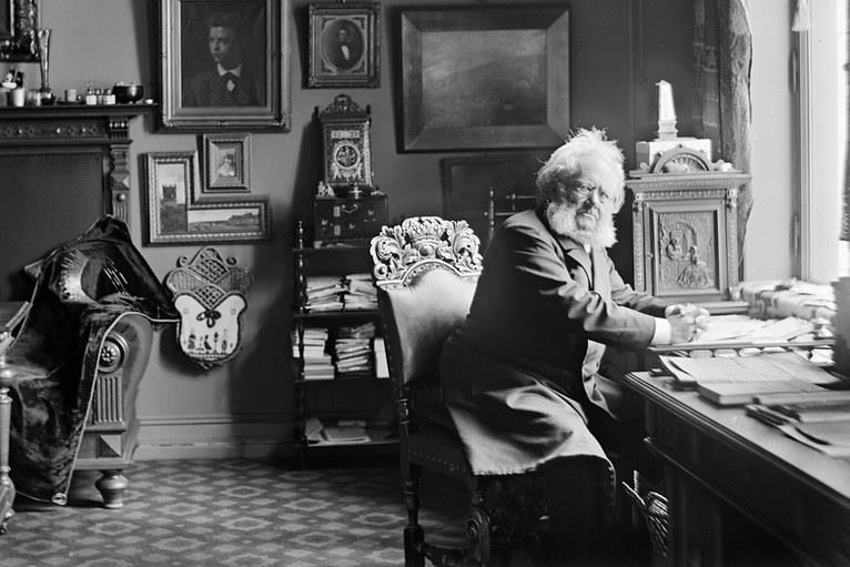 Black and white photograph of Henrik Ibsen at his desk