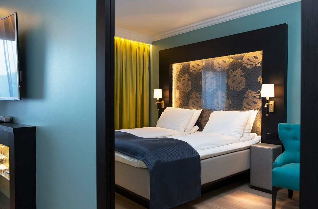 double room with large bed and TV in blue colours