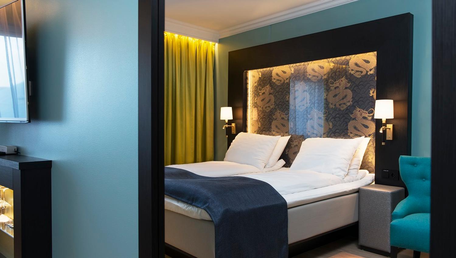 double room with large bed and TV in blue colours