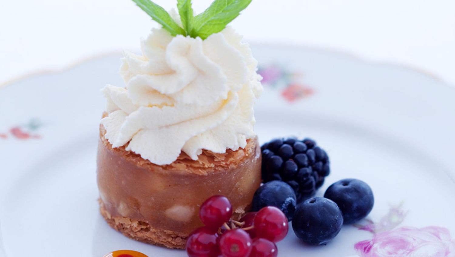 Detail photo of a dessert on a white plate with flowers on.