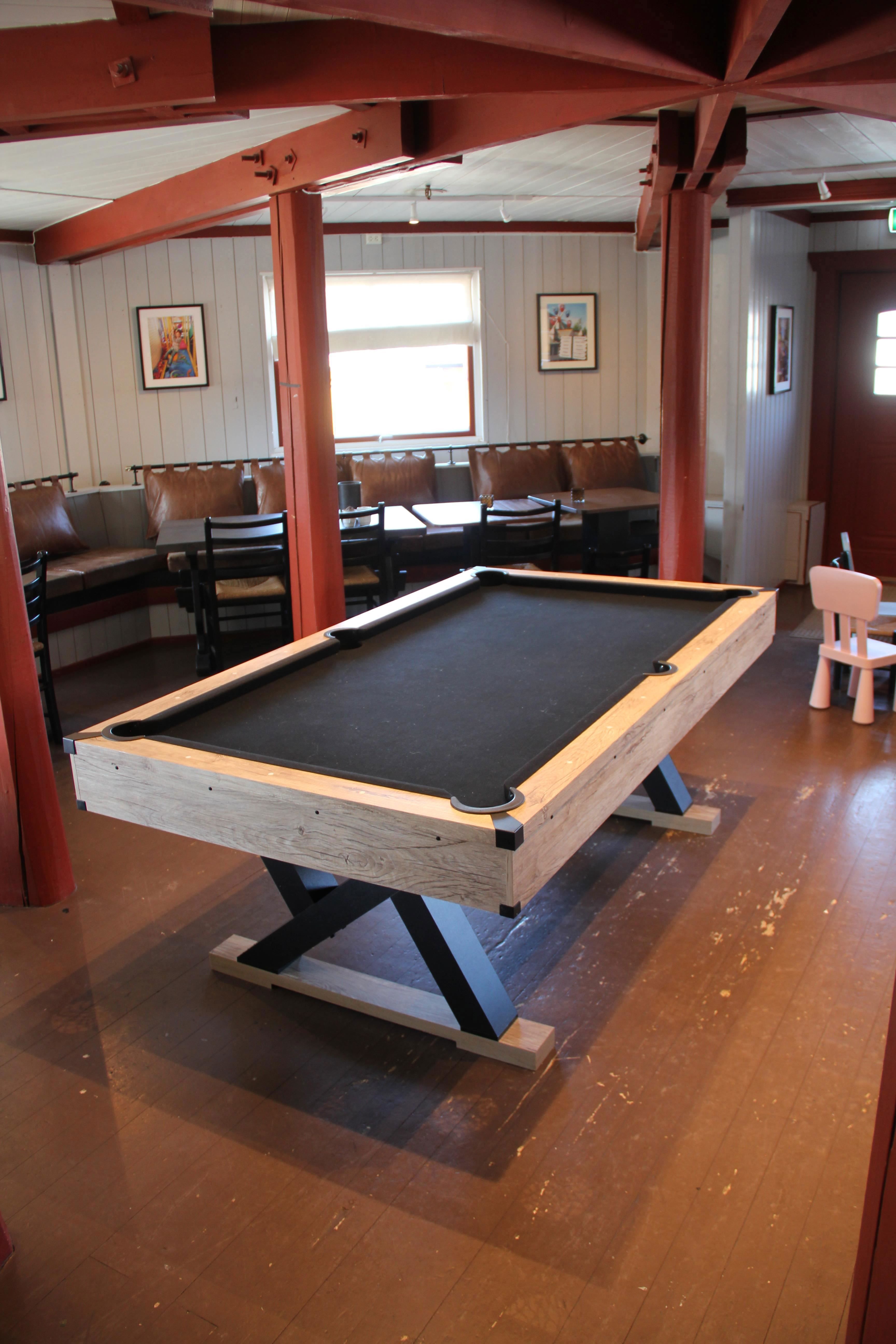 A pool table on a wooden floor.