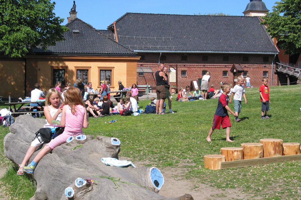 Et hus og mange mennsker på en plen.