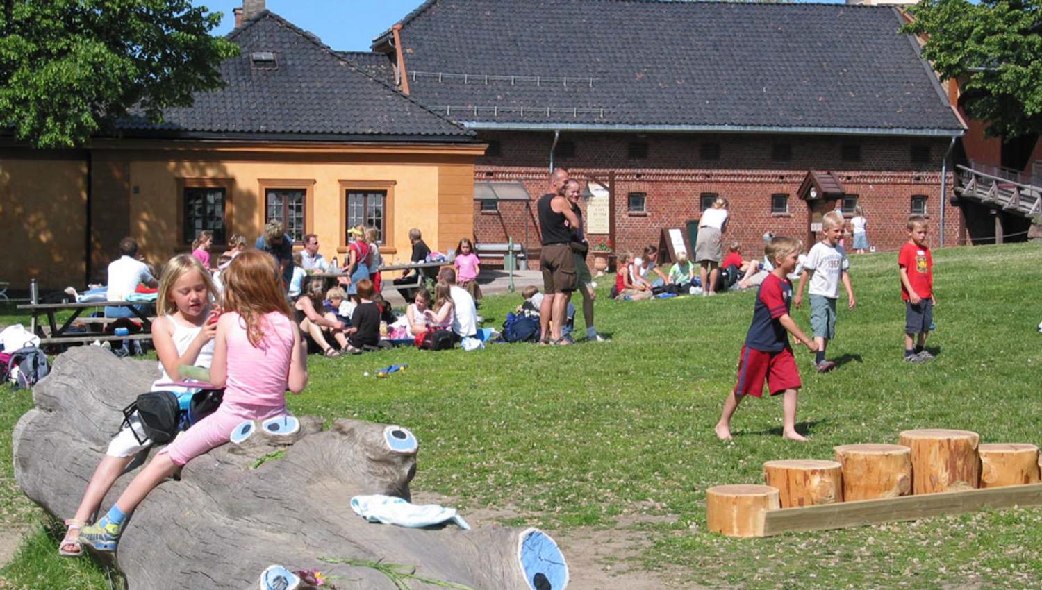 Et hus og mange mennsker på en plen.