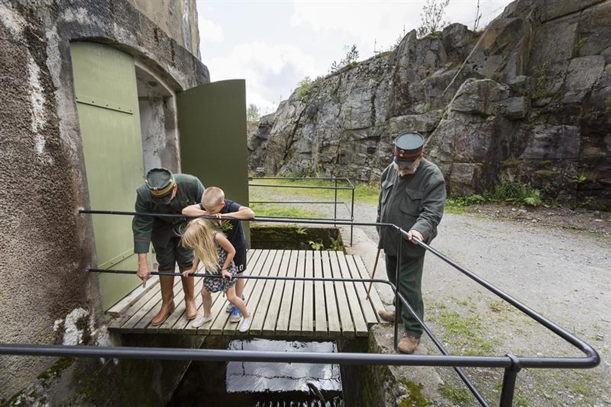 to menn i militær uniform og to barn som utforsker en festning