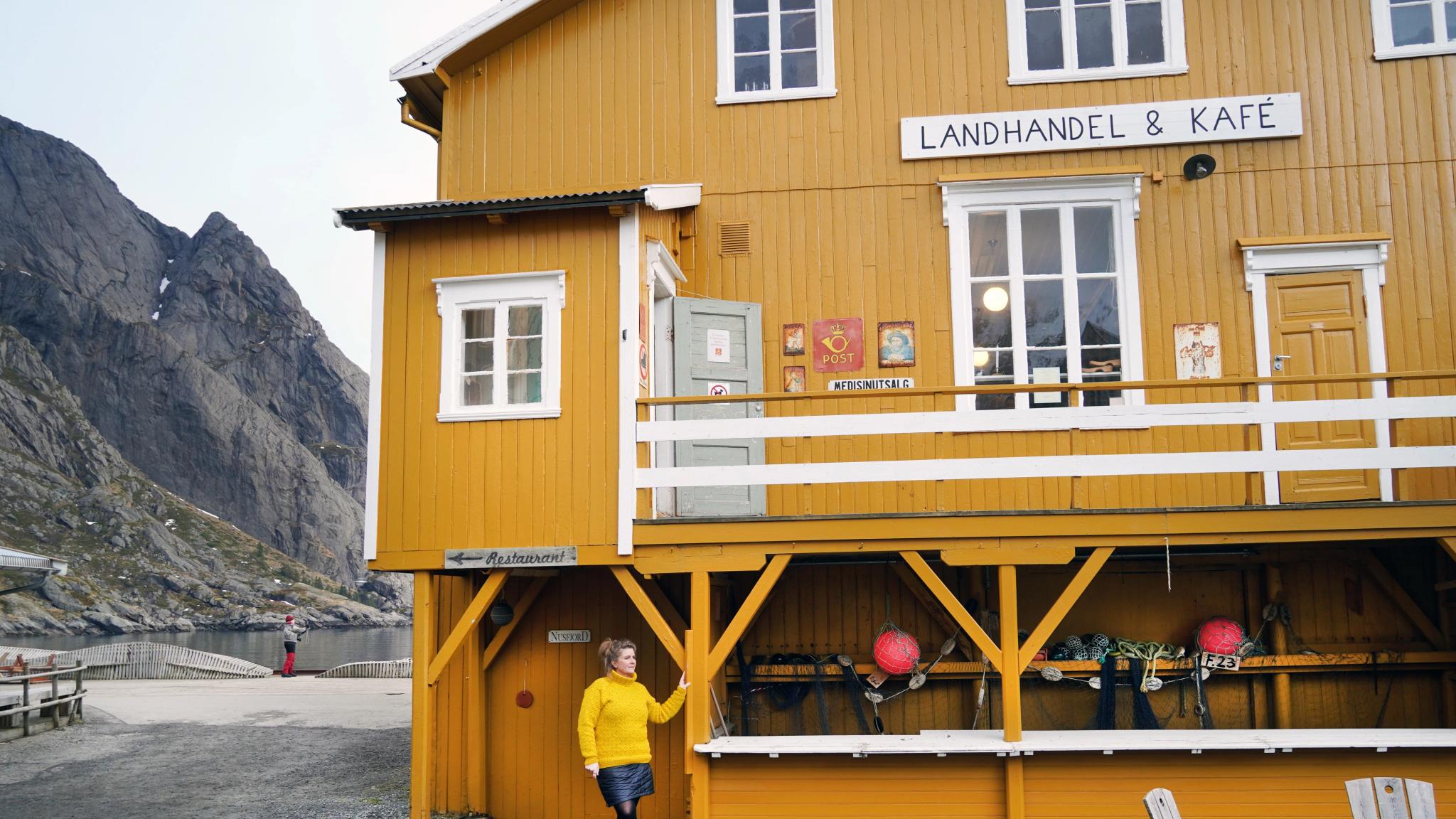 Woman outside the Nusfjord Landhandel shop