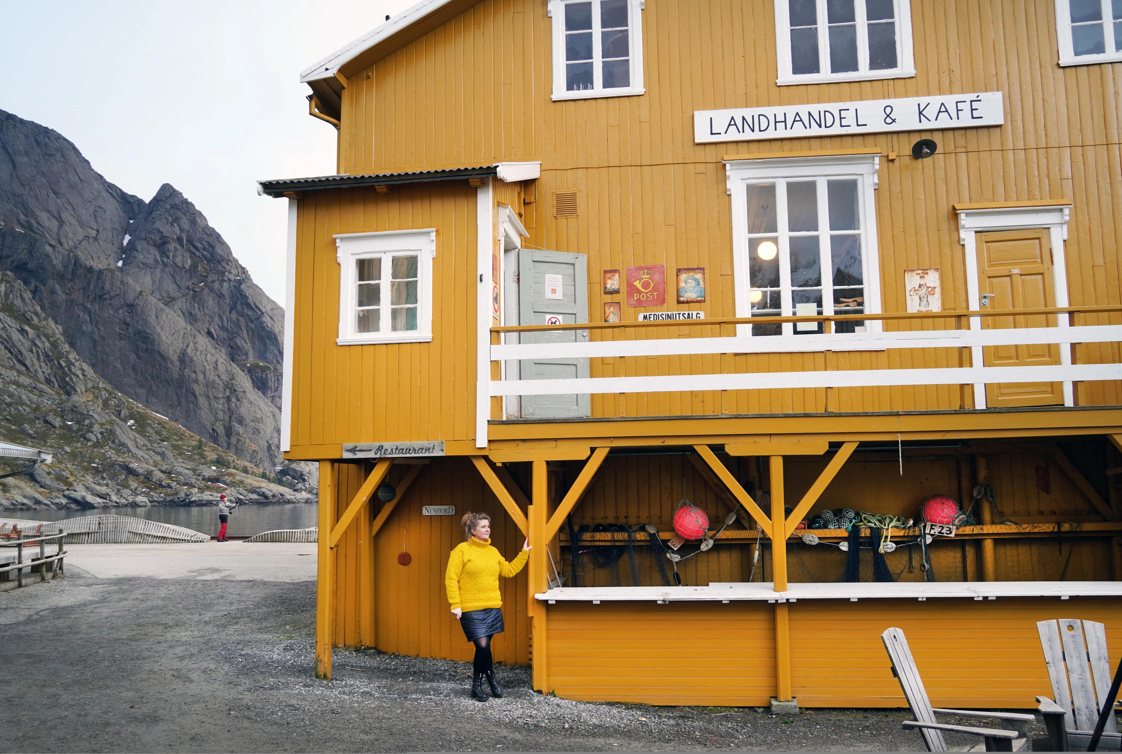Woman outside the Nusfjord Landhandel shop
