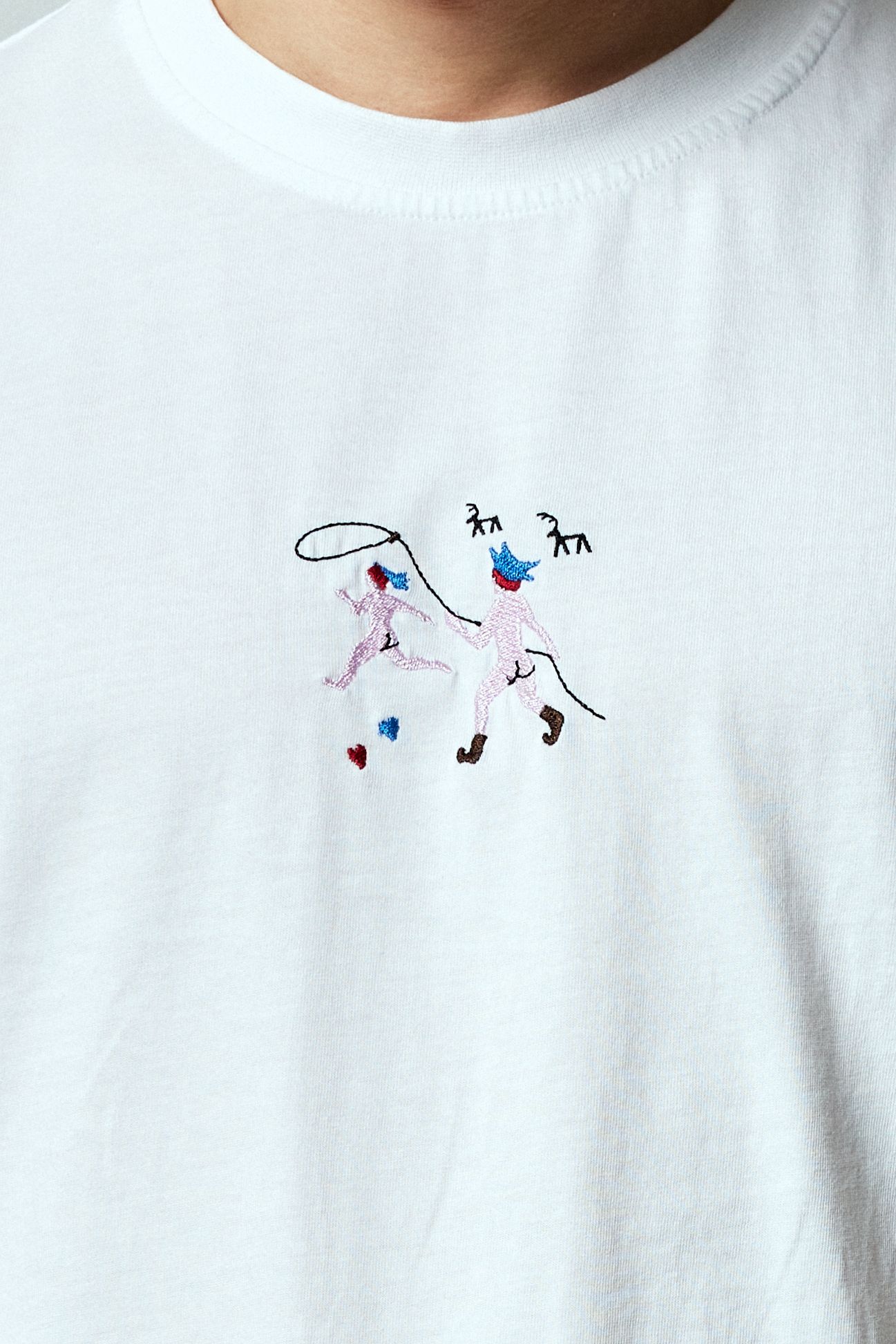 Embroidery of a naked Sami chasing another with a lasso