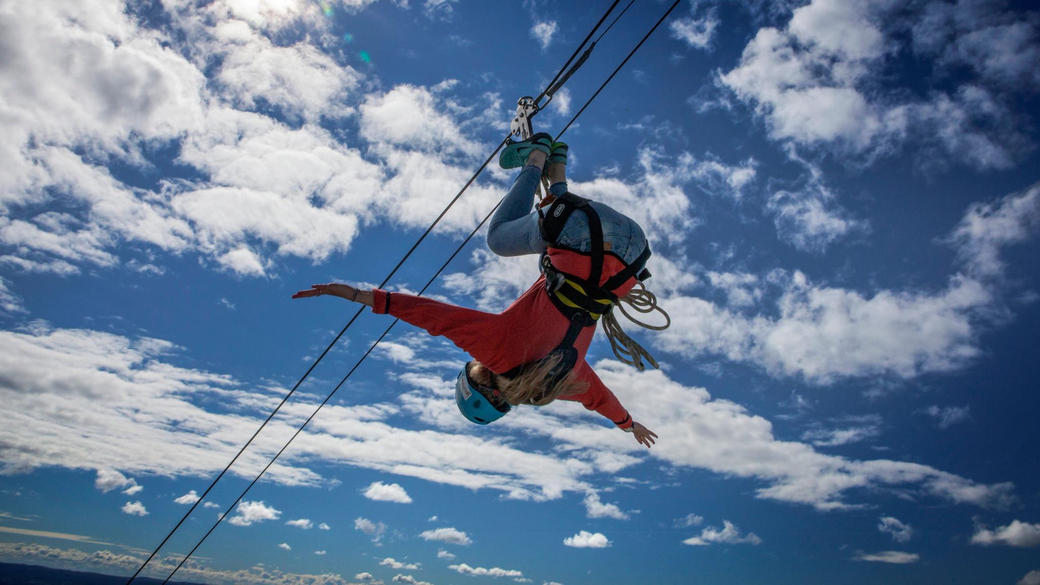 Woman ziplining upside down